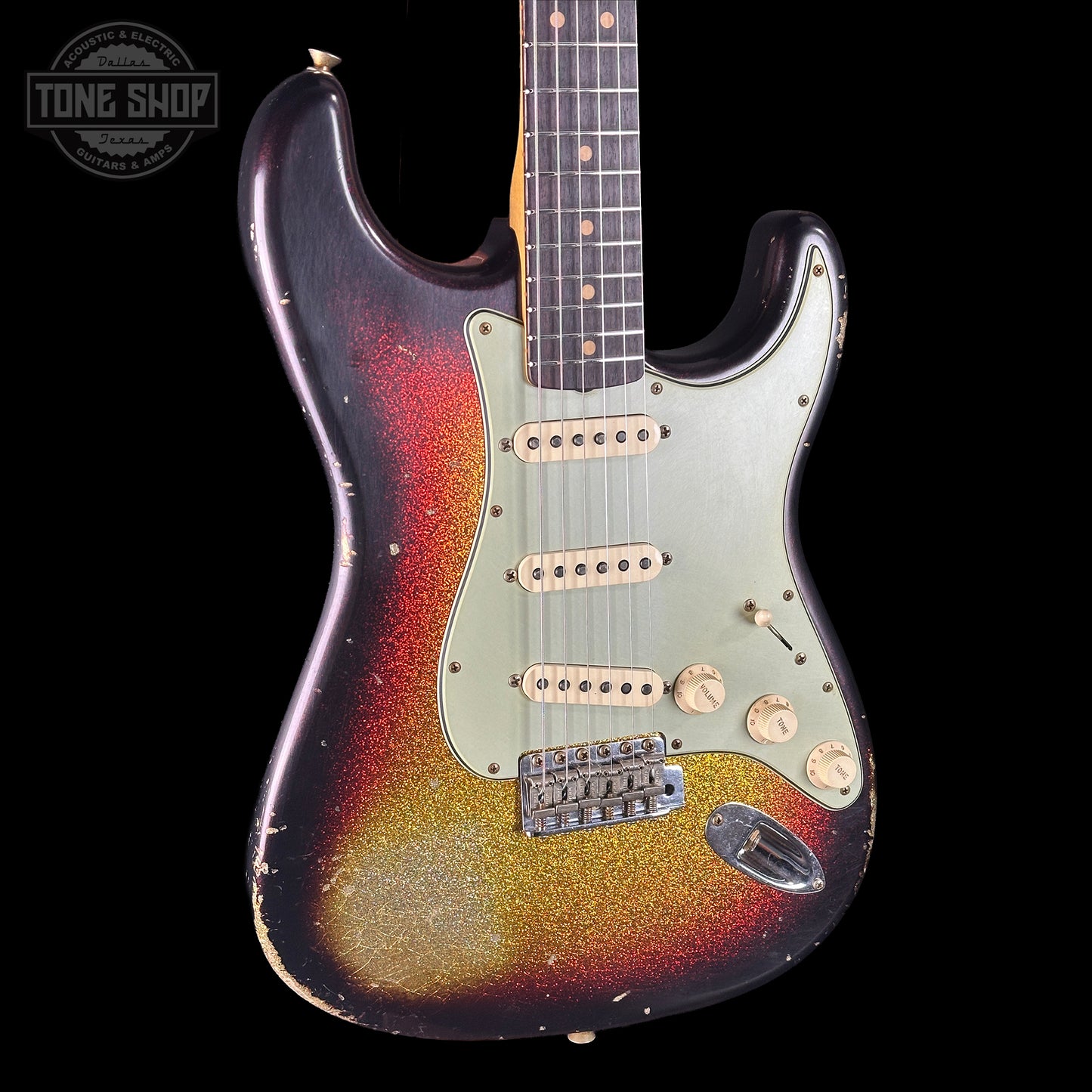 Fender Stratocaster guitar with sunburst finish on a black background, Tone Shop logo visible.