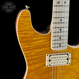 Close-up of a sunburst electric guitar with a visible brand logo in the corner.