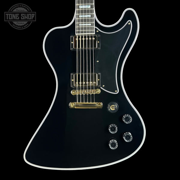 Black electric guitar with gold hardware on a black background, featuring 'Tone Shop' logo.
