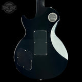 The back of a black Gibson electric guitar, showing the glossy finish, pickguard, and a silver Gibson logo badge on a black background.