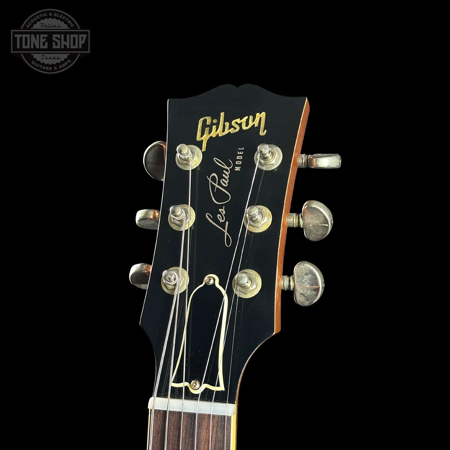 Gibson Les Paul guitar headstock with brand logo on a black background
