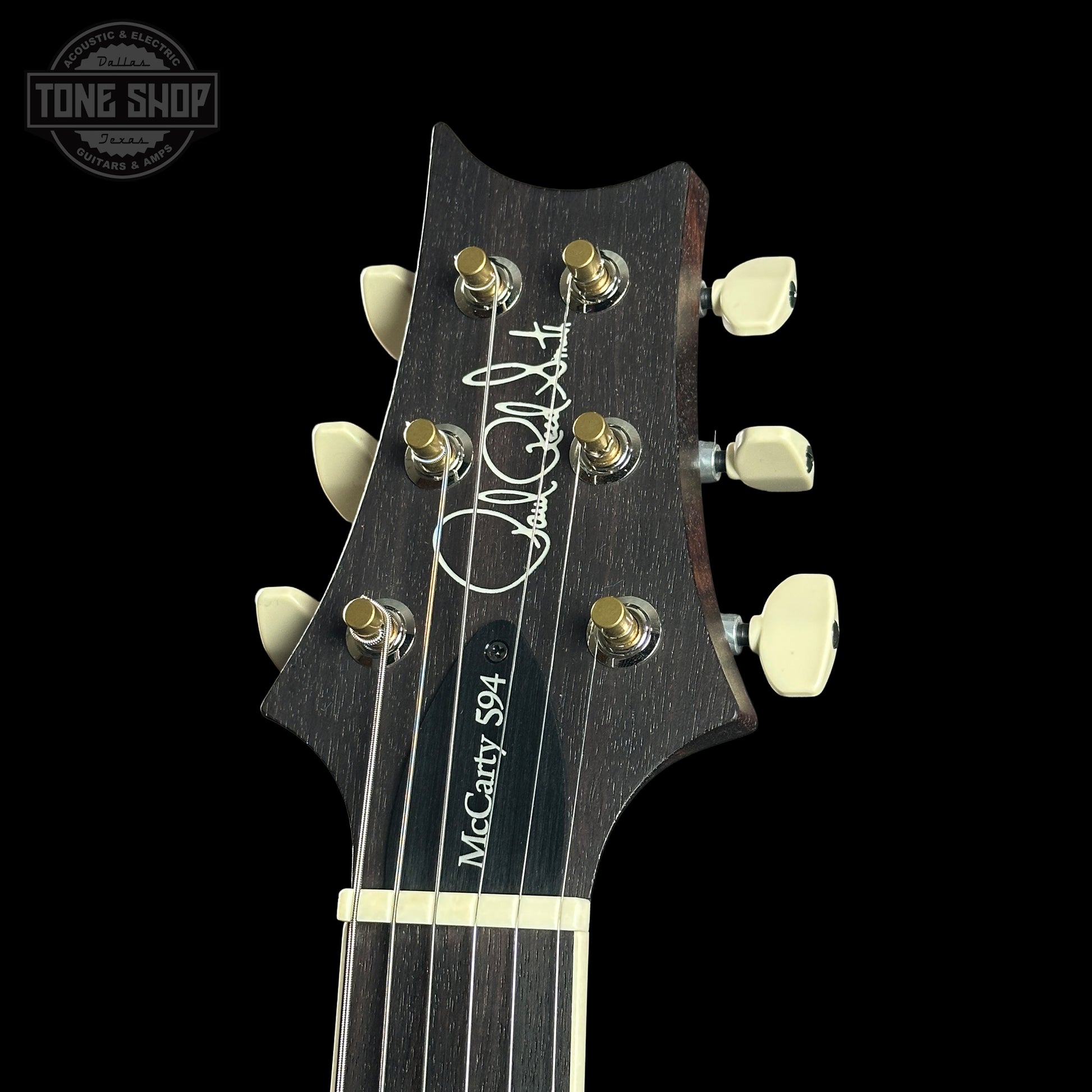 Guitar headstock with brand name on a black background