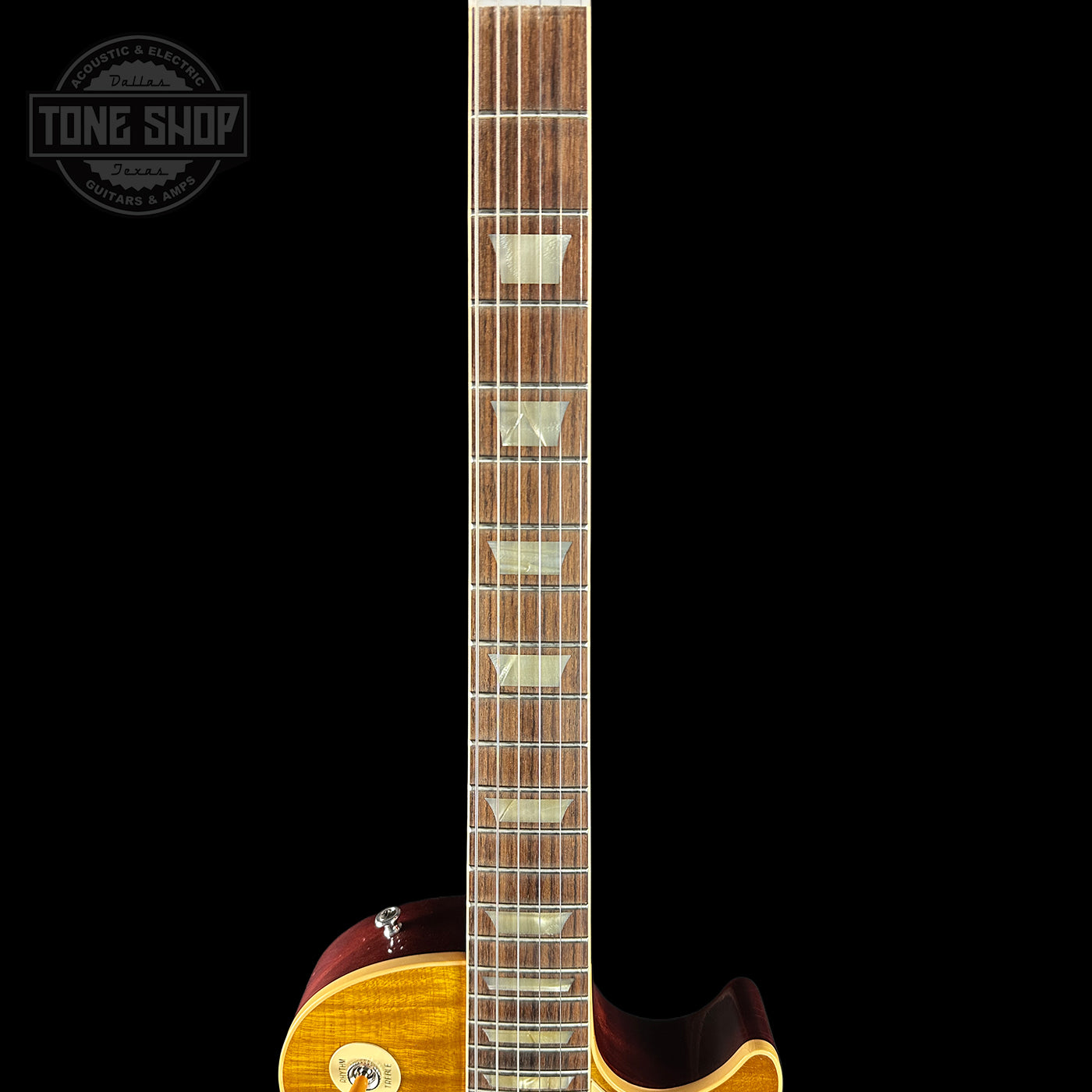 Guitar neck with a close-up view on a black background, featuring the Tone Shop logo.