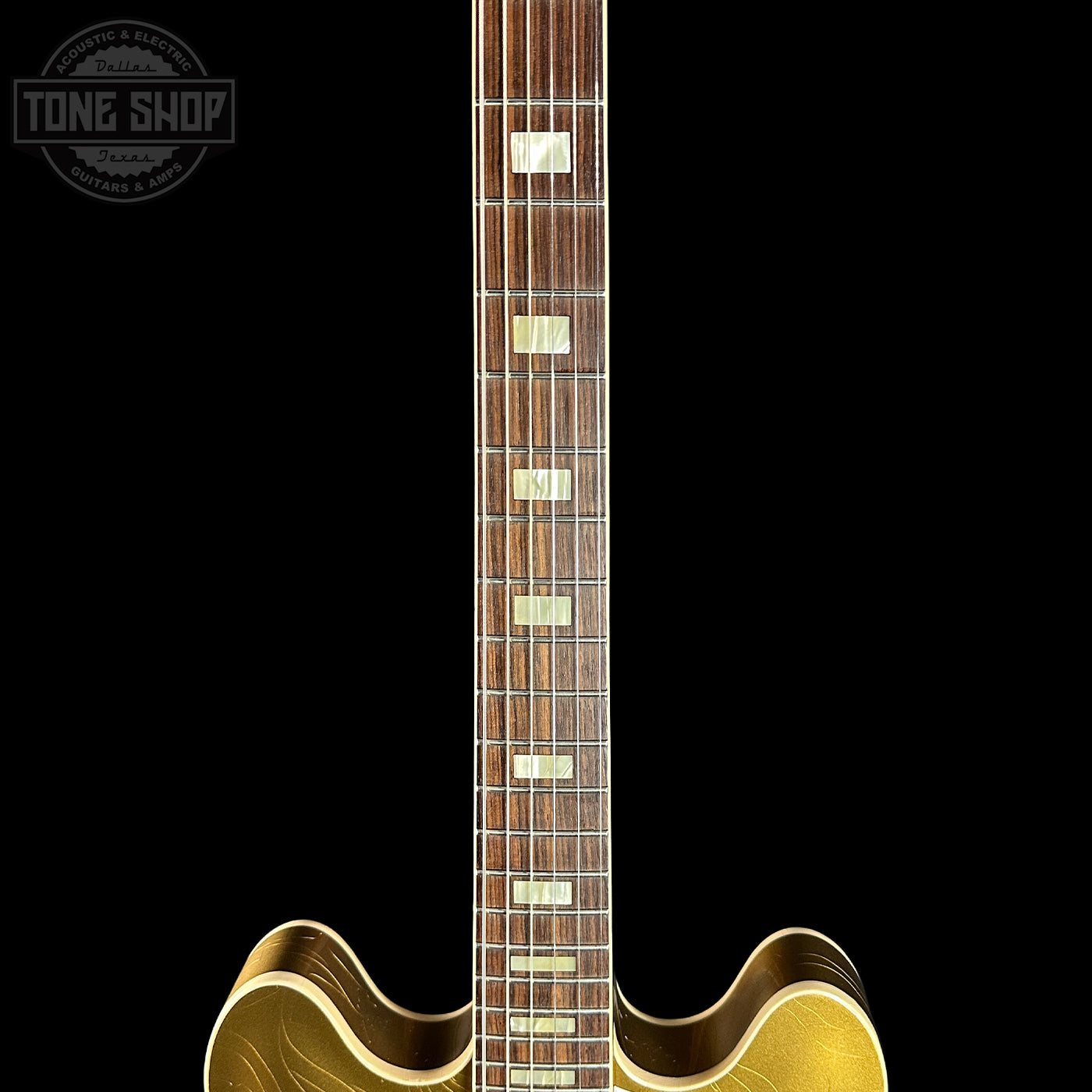 Close-up of a guitar neck with a visible brand logo in the corner.