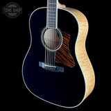 Acoustic guitar with black finish and wooden body on a black background