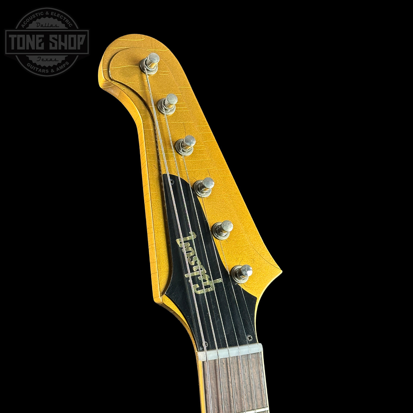 Close-up of a guitar headstock with 'Tone Shop' branding on a black background