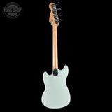 Electric guitar with a light gray body and wooden neck on a black background, featuring 'Tone Shop' branding.