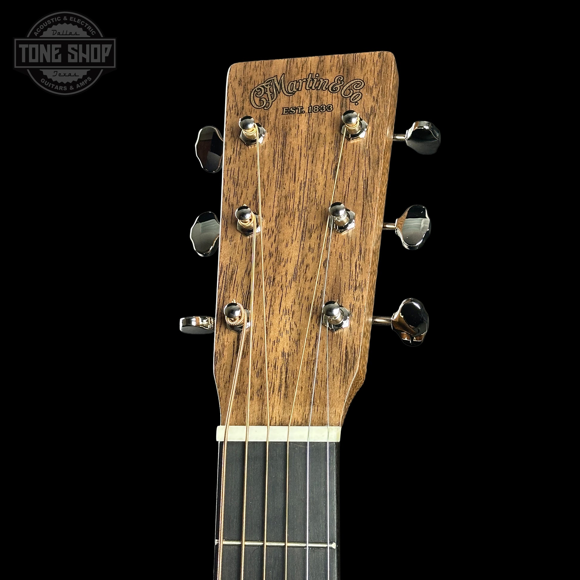 Close-up of a guitar headstock with 'Martin' branding on a black background