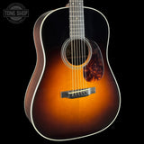 Acoustic guitar with a sunburst finish on a black background, featuring the Tone Shop logo.
