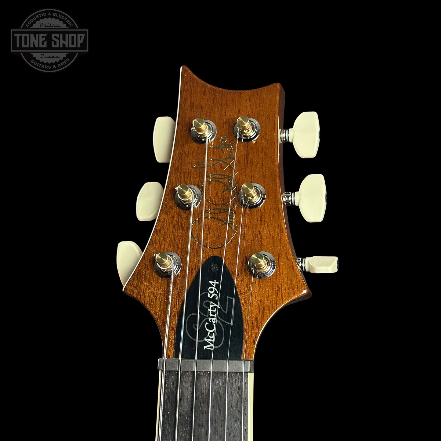 Guitar headstock with brand name on a black background