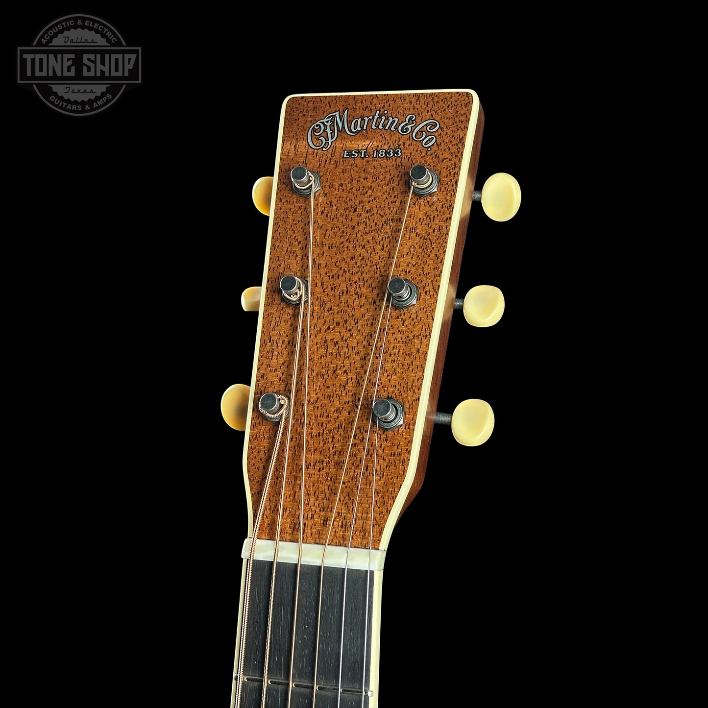 Close-up of a guitar headstock with 'Martin' branding on a black background