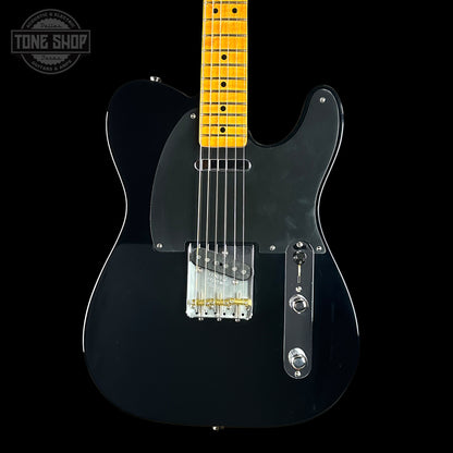 Black electric guitar with a yellow pickguard on a black background, featuring 'Tone Shop' branding.