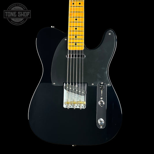 Black electric guitar with a yellow pickguard on a black background, featuring 'Tone Shop' branding.