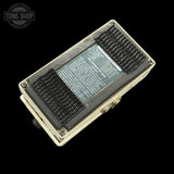 Electronic device with a metallic casing on a black background, featuring the 'Tone Shop' logo.