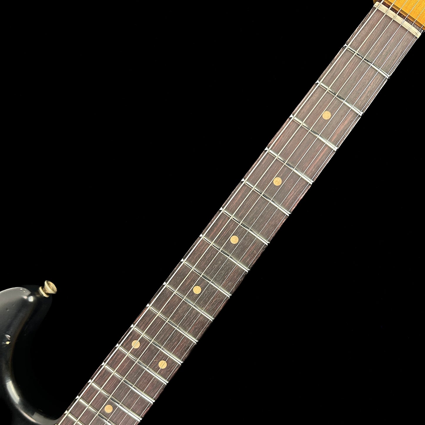 Fretboard of Fender Custom Shop Limited Edition '62 Strat Heavy Relic Aged Black Over 3 Color Sunburst.