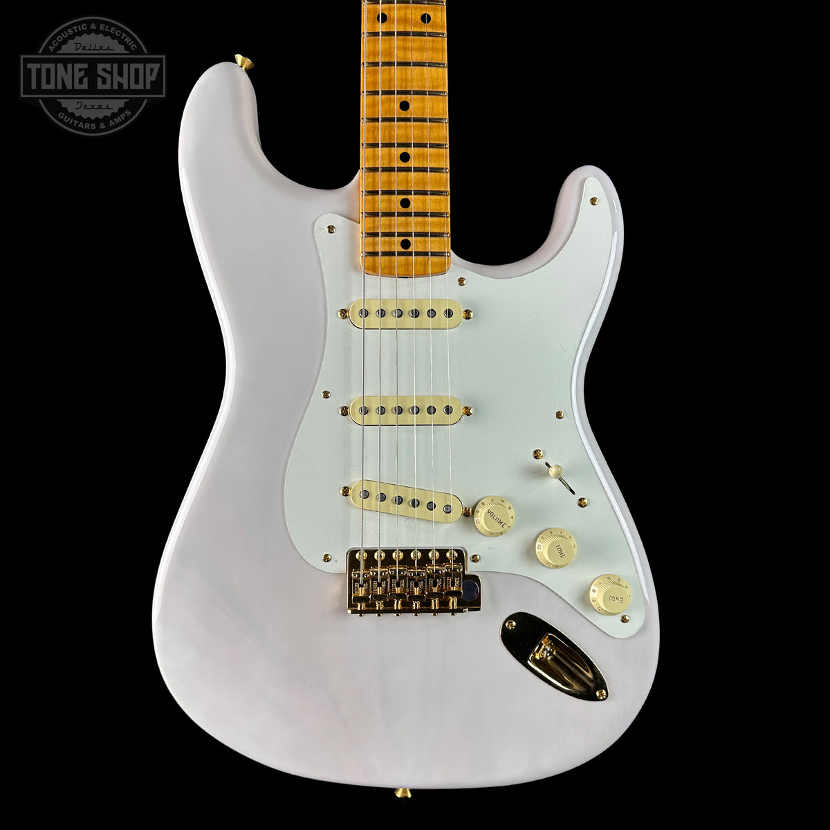 White electric guitar with a black background, featuring the Tone Shop logo.