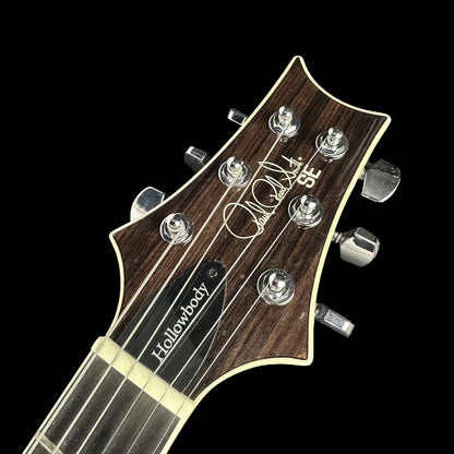 Front of headstock of Used PRS SE Hollowbody Black Gold Burst.