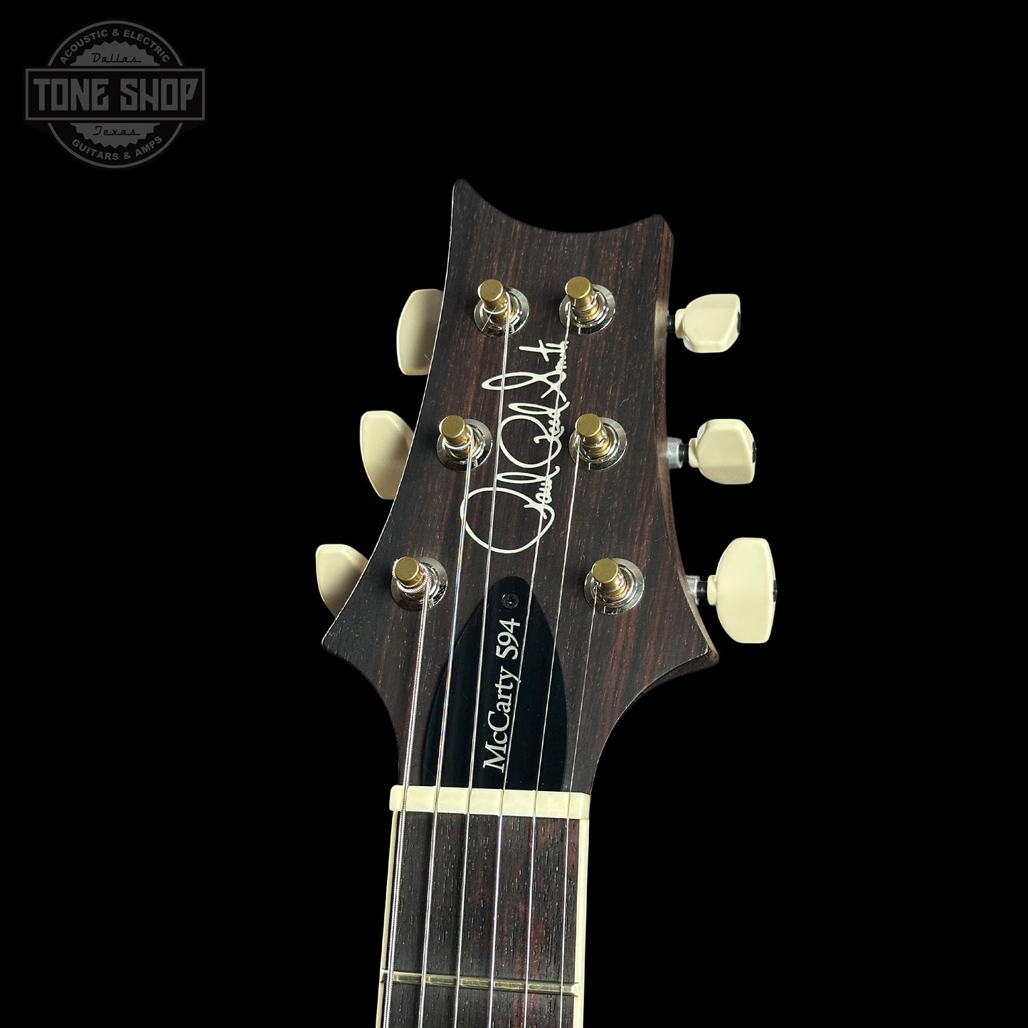 Guitar headstock with brand logo on a black background