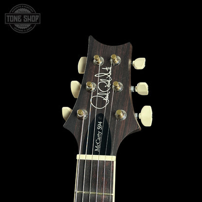 Guitar headstock with brand logo on a black background