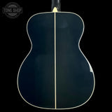 The back of an acoustic guitar with a glossy dark navy blue finish and a gold center stripe, shown against a solid black background.