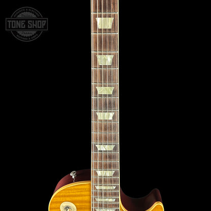 Close-up of a guitar neck with a dark background, featuring the 'Tone Shop' logo.