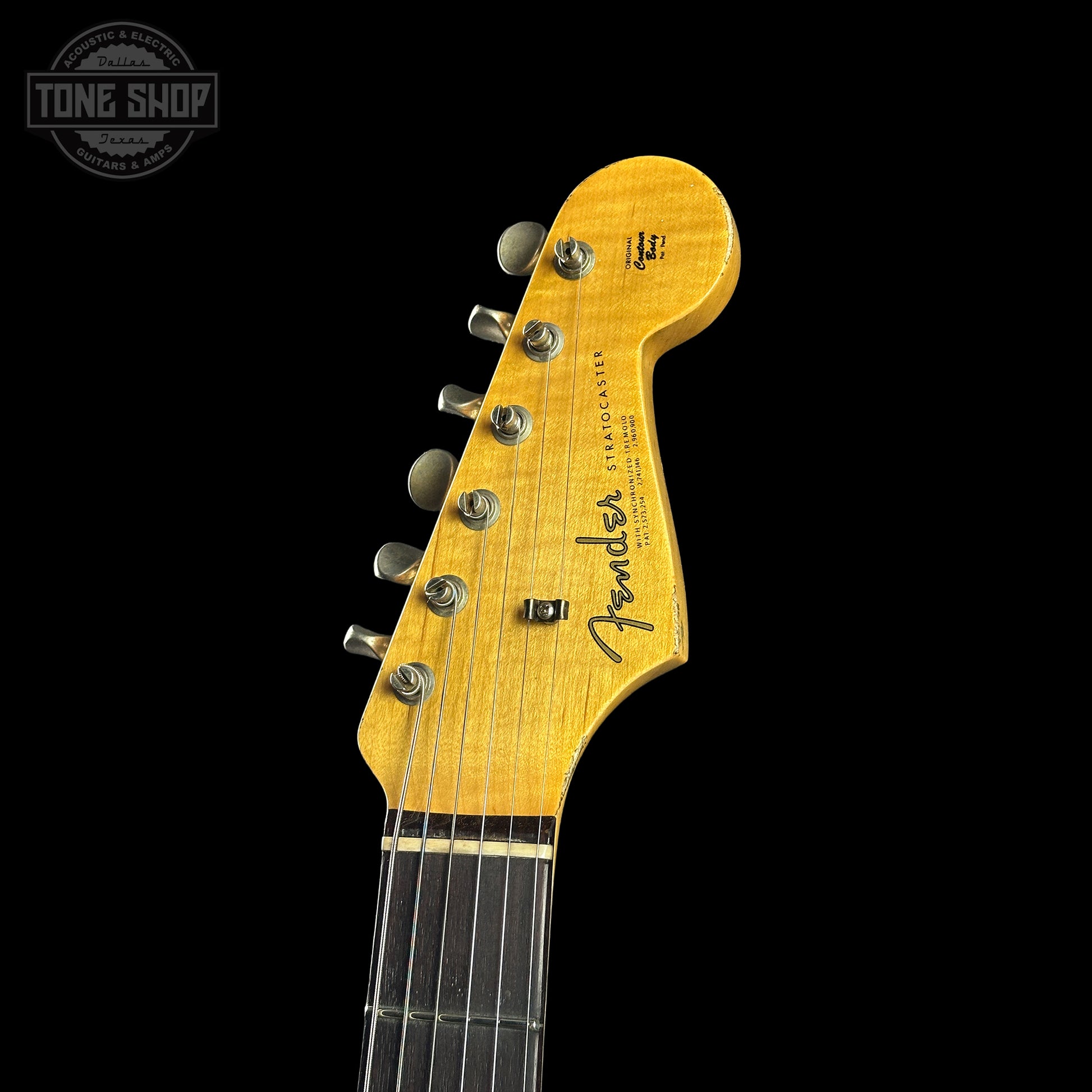 Close-up of a Fender electric guitar headstock on a black background