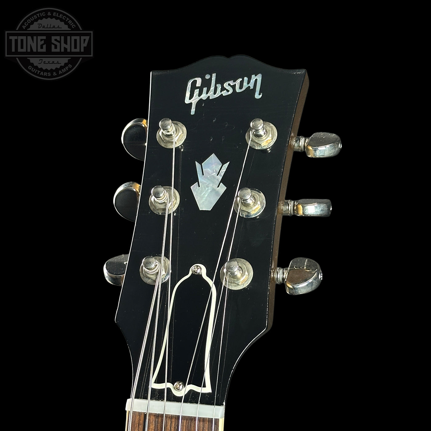 Gibson guitar headstock with brand logo on a black background