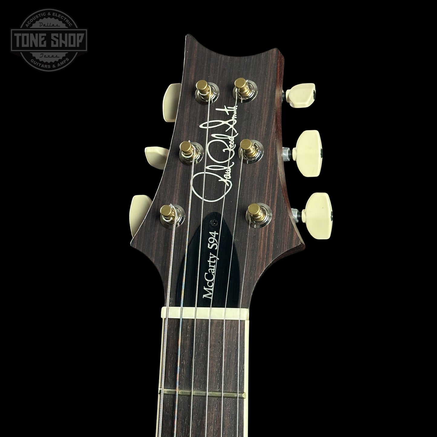 Guitar headstock with brand name on a black background