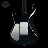 Black electric guitar with silver pickguard on a black background, featuring 'Tone Shop' logo.