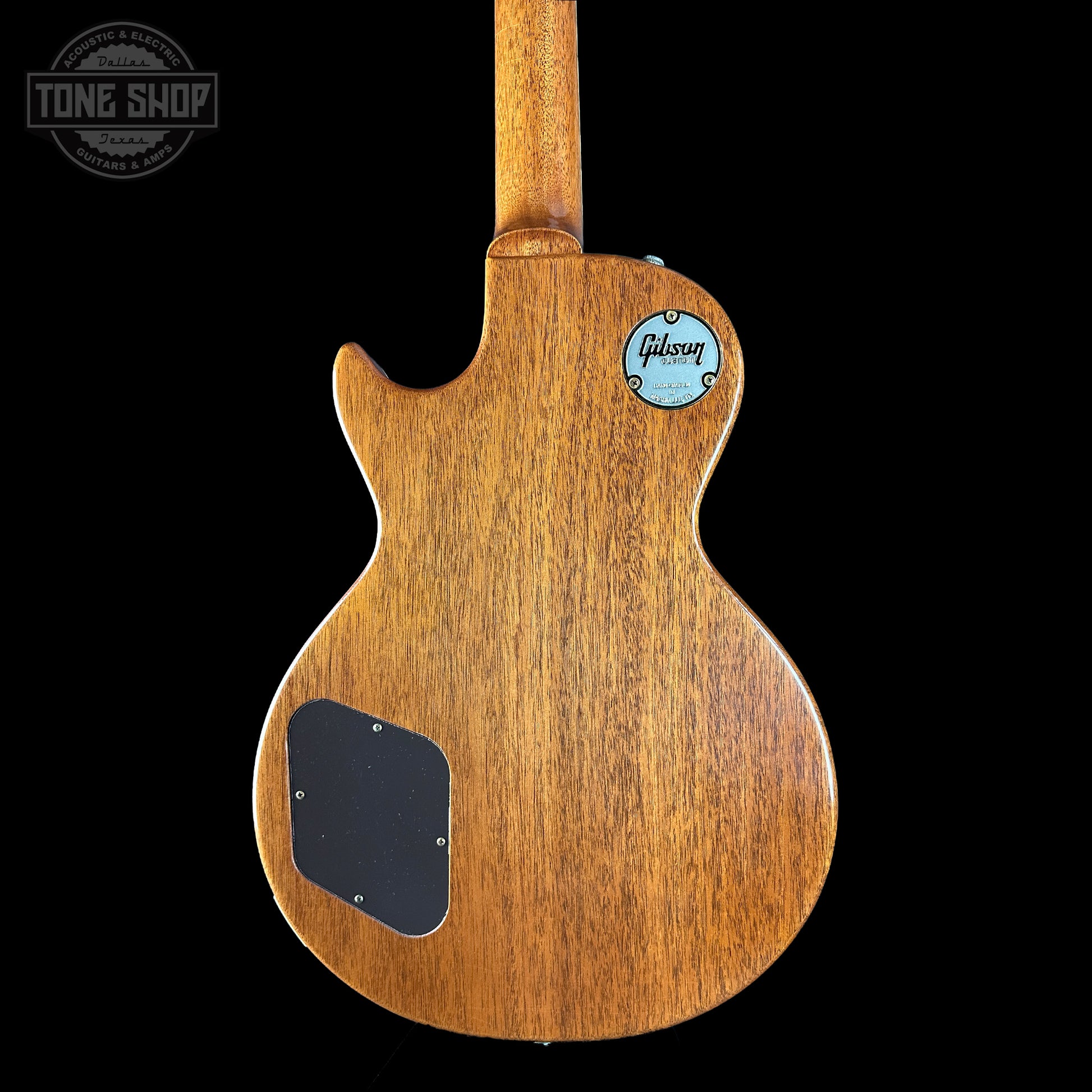 Back view of a wooden guitar with a visible Gibson logo on a black background.