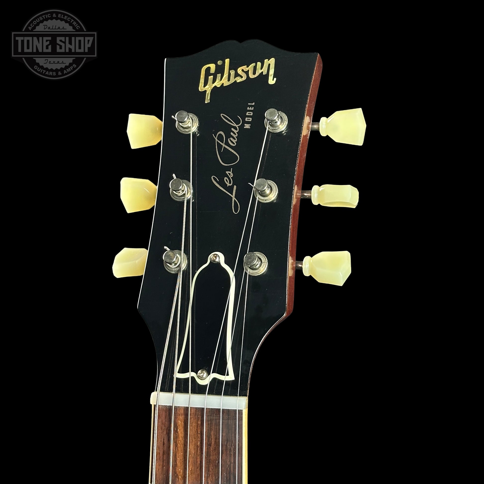 Gibson Les Paul guitar headstock with brand logo on a black background
