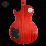 Red electric guitar body with a visible brand logo on a black background