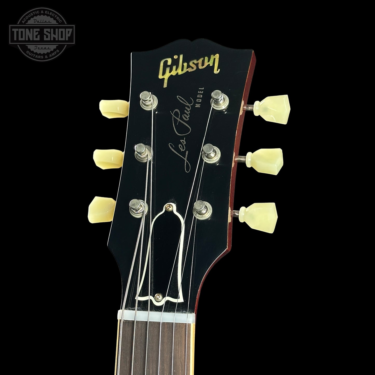 Gibson Les Paul guitar headstock with brand name on a black background