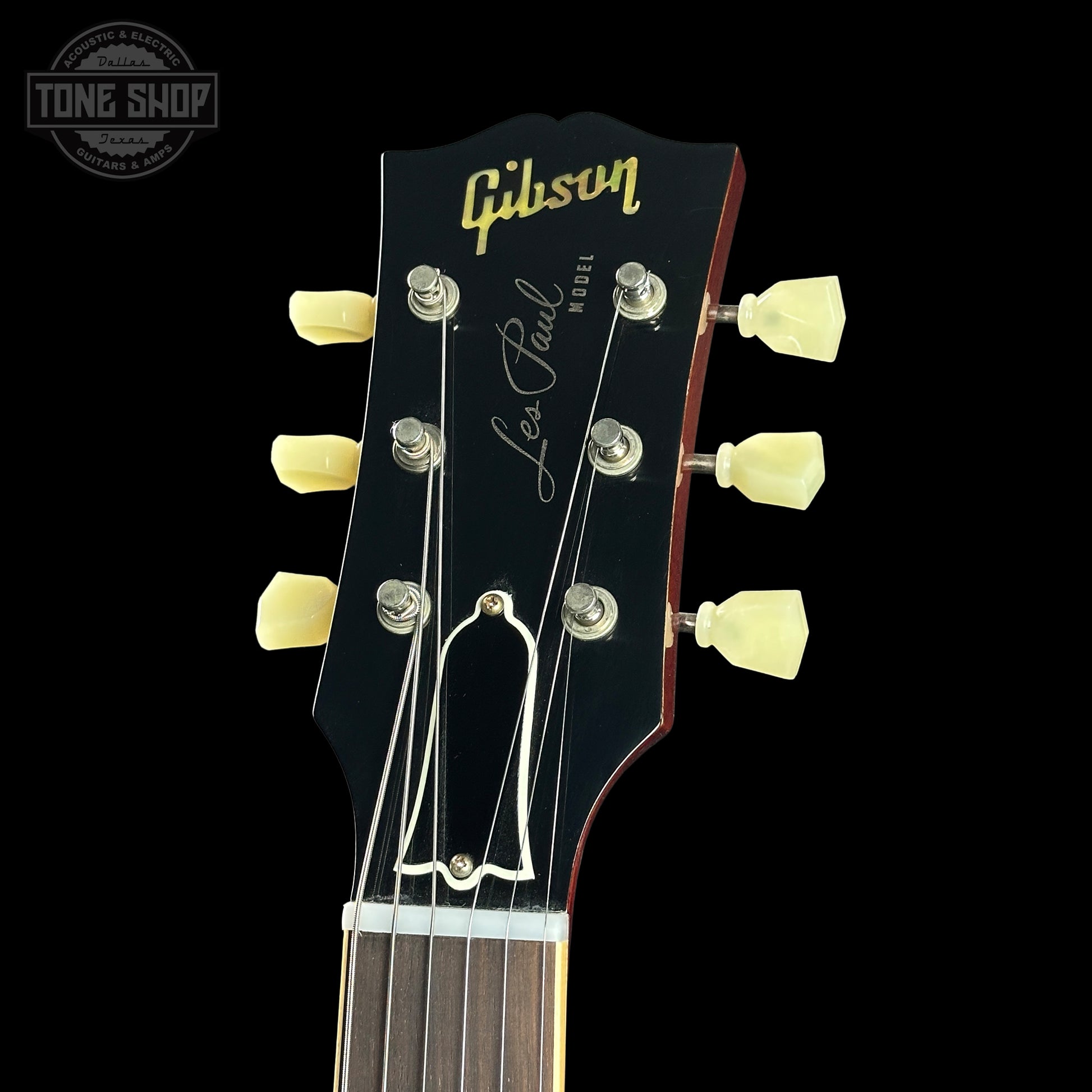 Gibson Les Paul guitar headstock with brand name on a black background