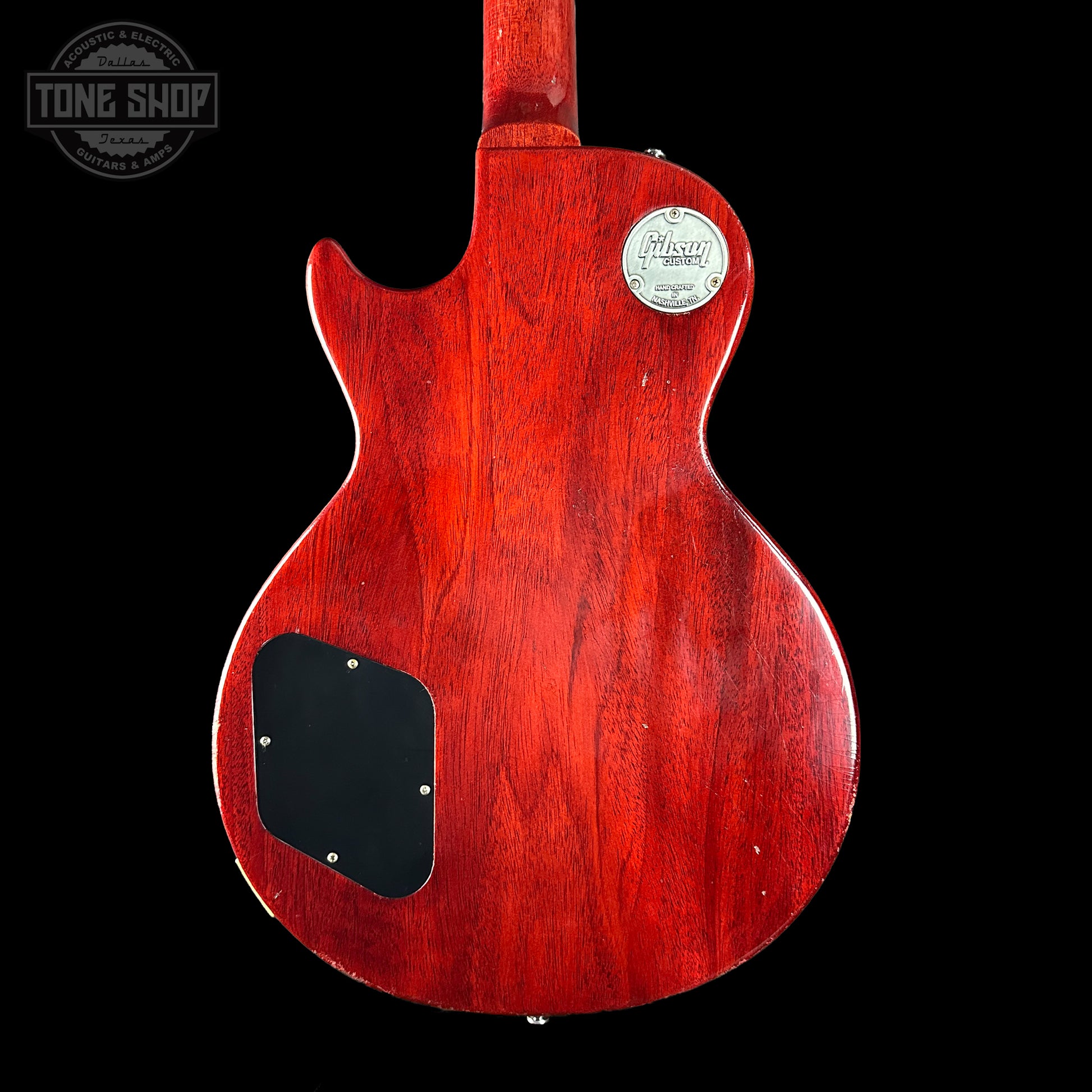 Red electric guitar body with a visible brand logo on a black background