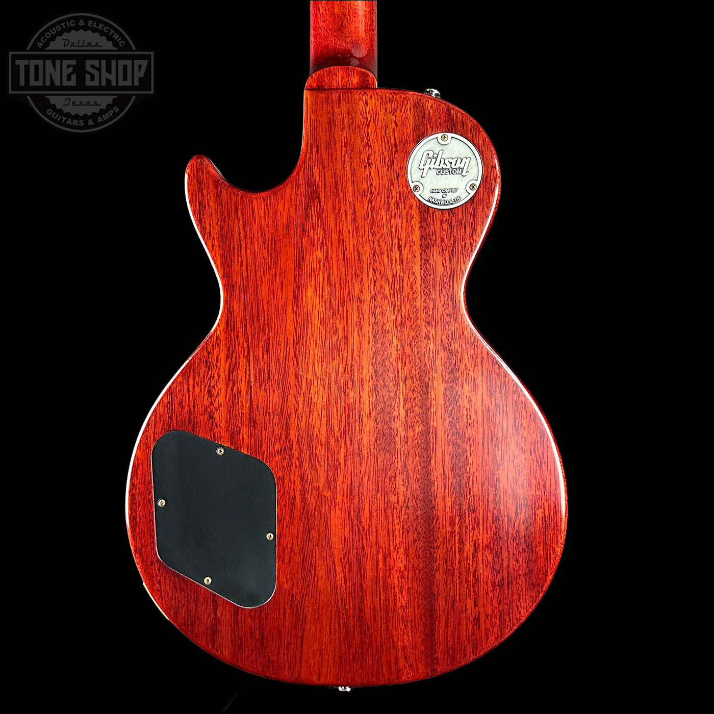 Back view of a red electric guitar with a visible brand logo on a black background