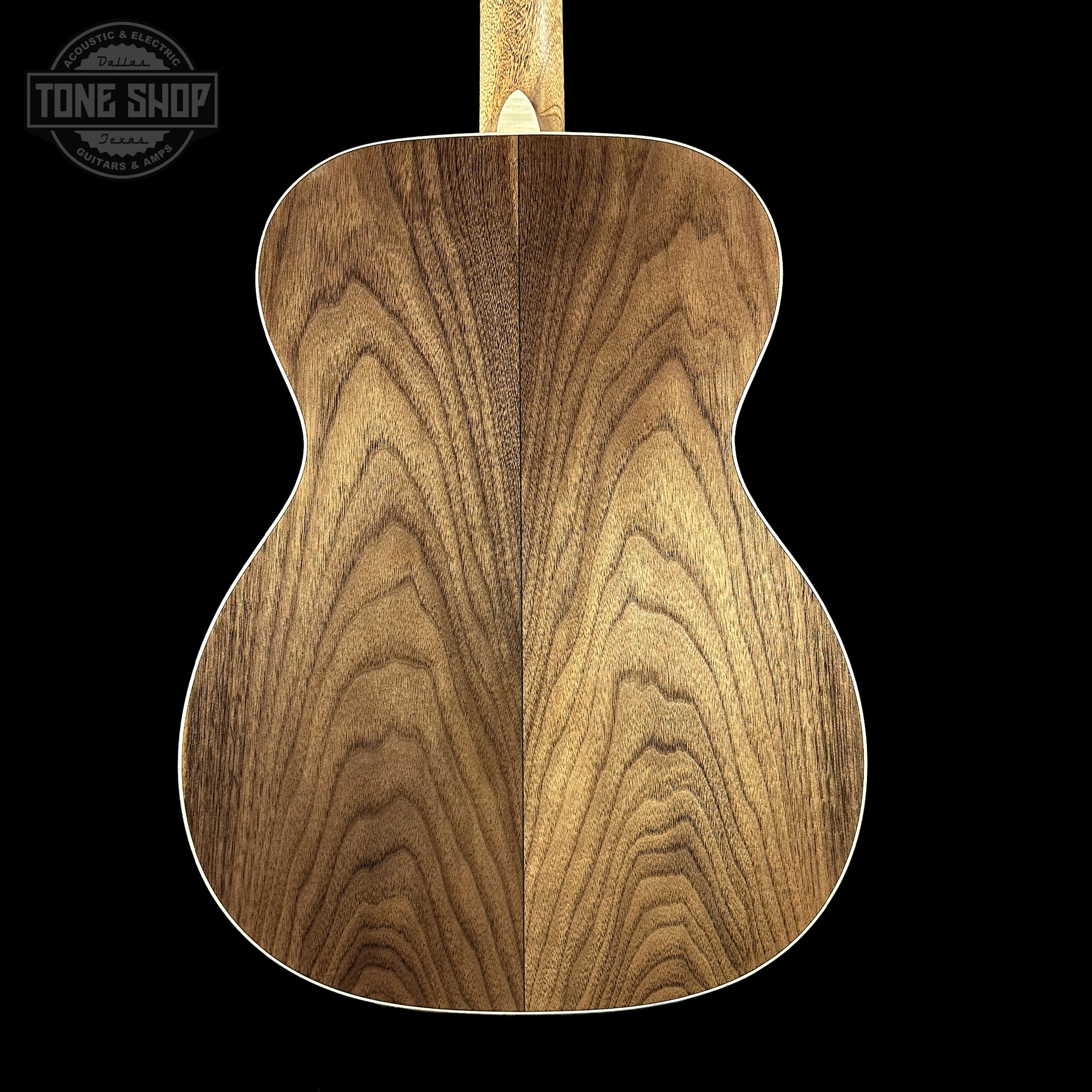 Close-up of a wooden acoustic guitar body with 'Tone Shop' logo in the corner.