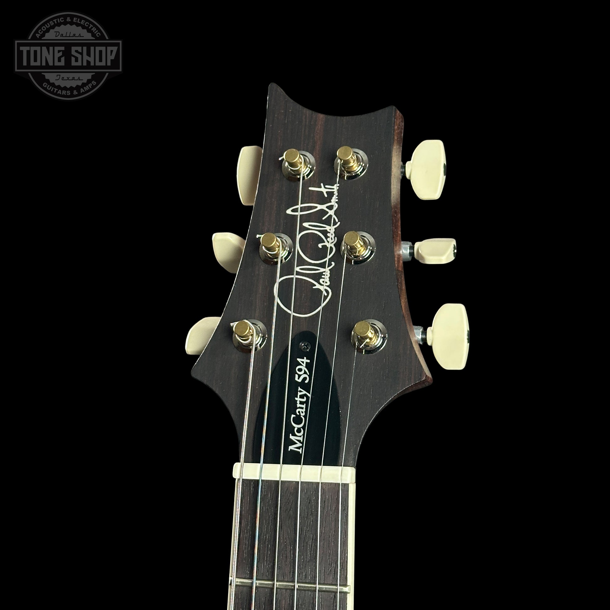Guitar headstock with brand logo on a black background