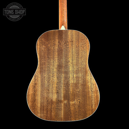 Back view of a wooden acoustic guitar with 'Tone Shop' logo.