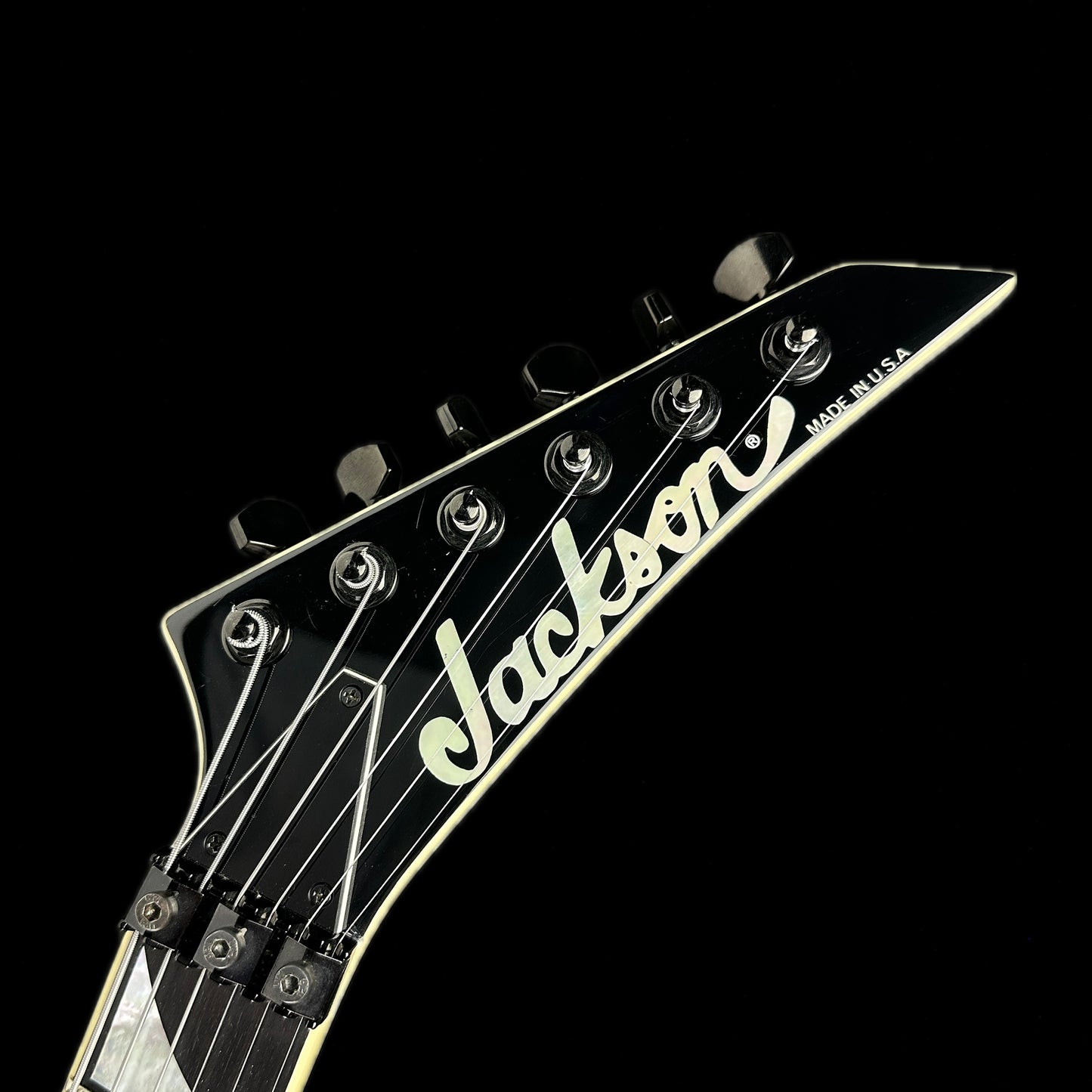 Front of headstock of Used 1997 Jackson USA RR-1 Rhoads V Pinstripe.