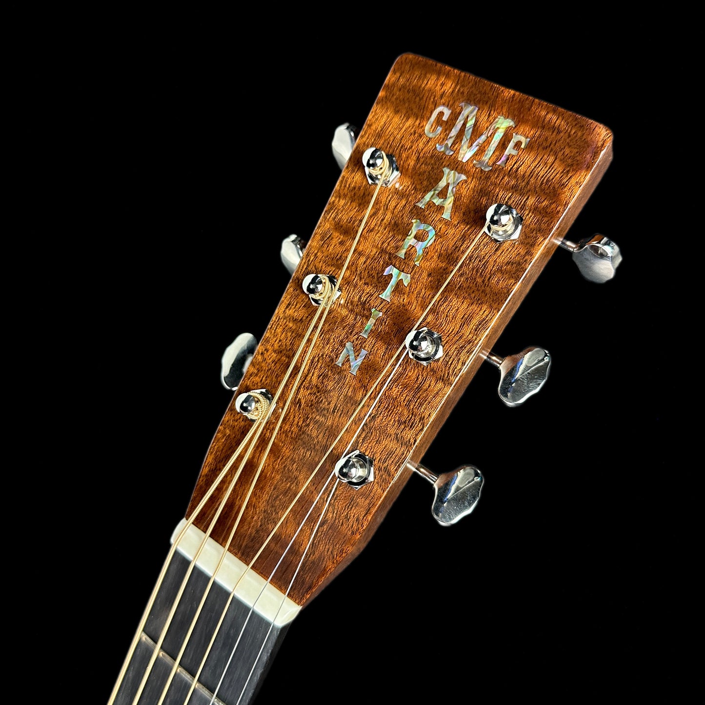 Front of headstock of Martin Custom Shop 28 Style Dread Adirondack/Quilted Sapele.