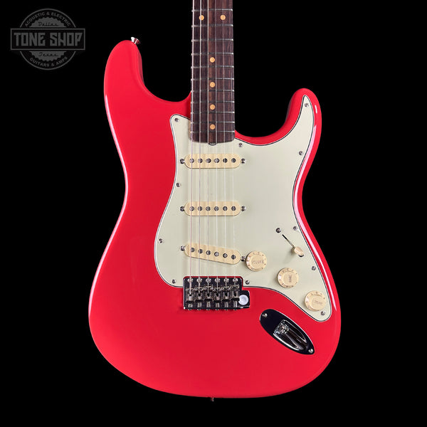 Red electric guitar with a white pickguard on a black background, featuring the Tone Shop logo.