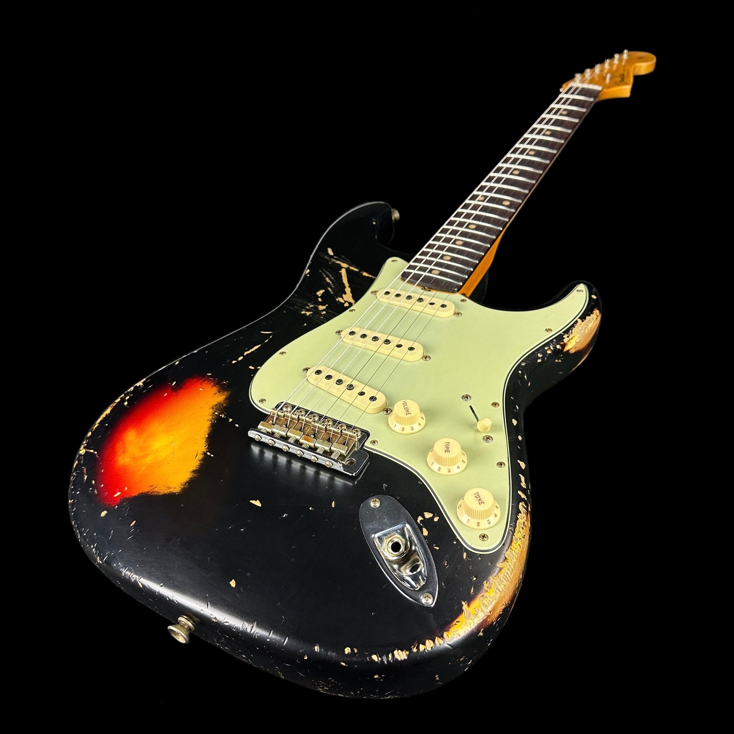 Front angle of Fender Custom Shop Limited Edition '62 Strat Heavy Relic Aged Black Over 3 Color Sunburst.