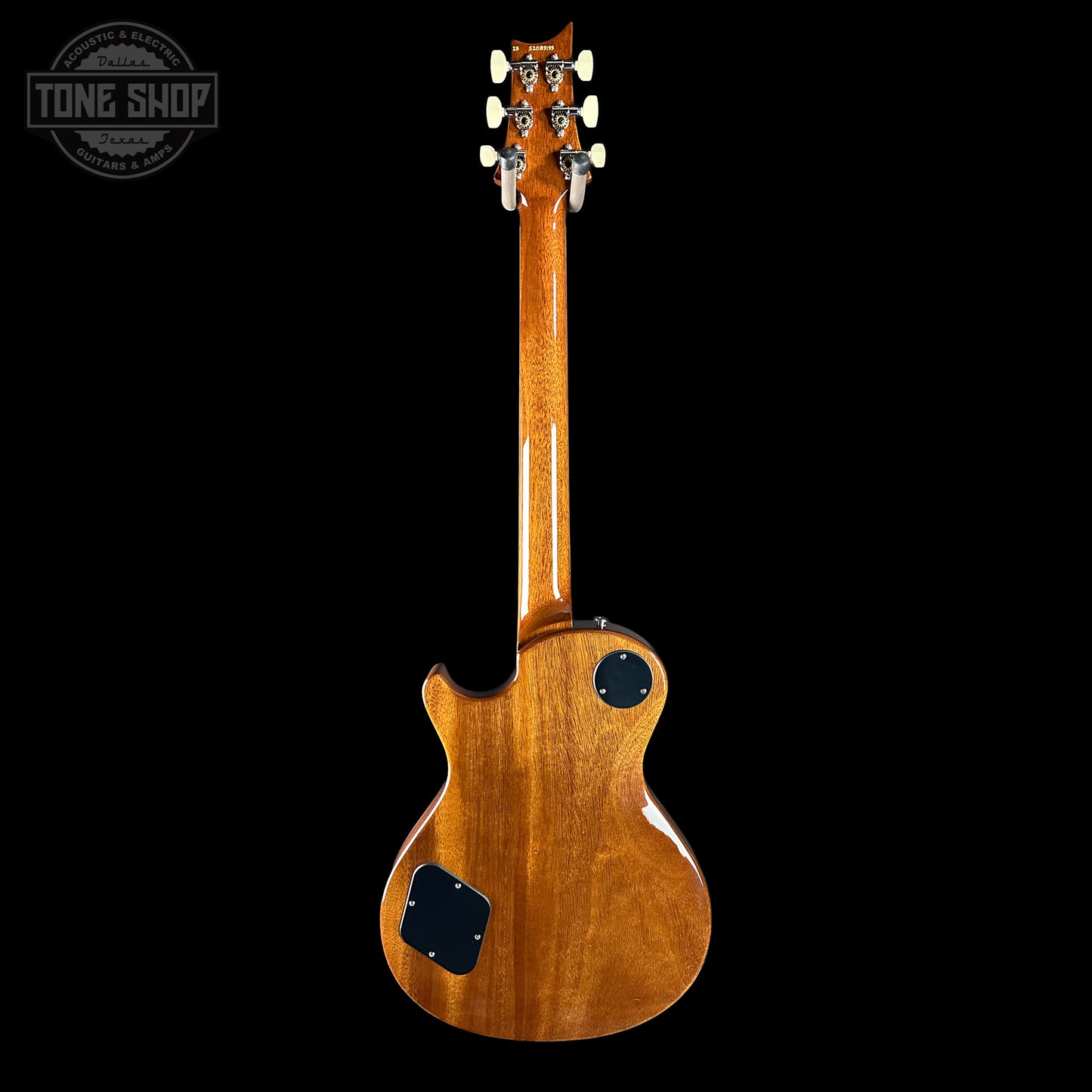 Back view of a wooden electric guitar on a black background with 'Tone Shop' logo.