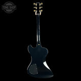 Black electric guitar with headstock on a black background, featuring 'Tone Shop' logo.
