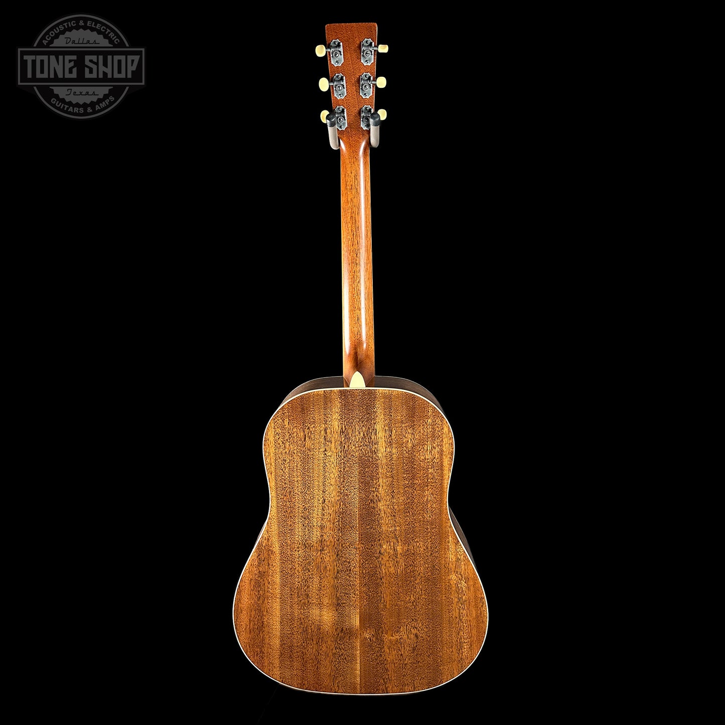 Back view of a wooden acoustic guitar on a black background with 'Tone Shop' logo.