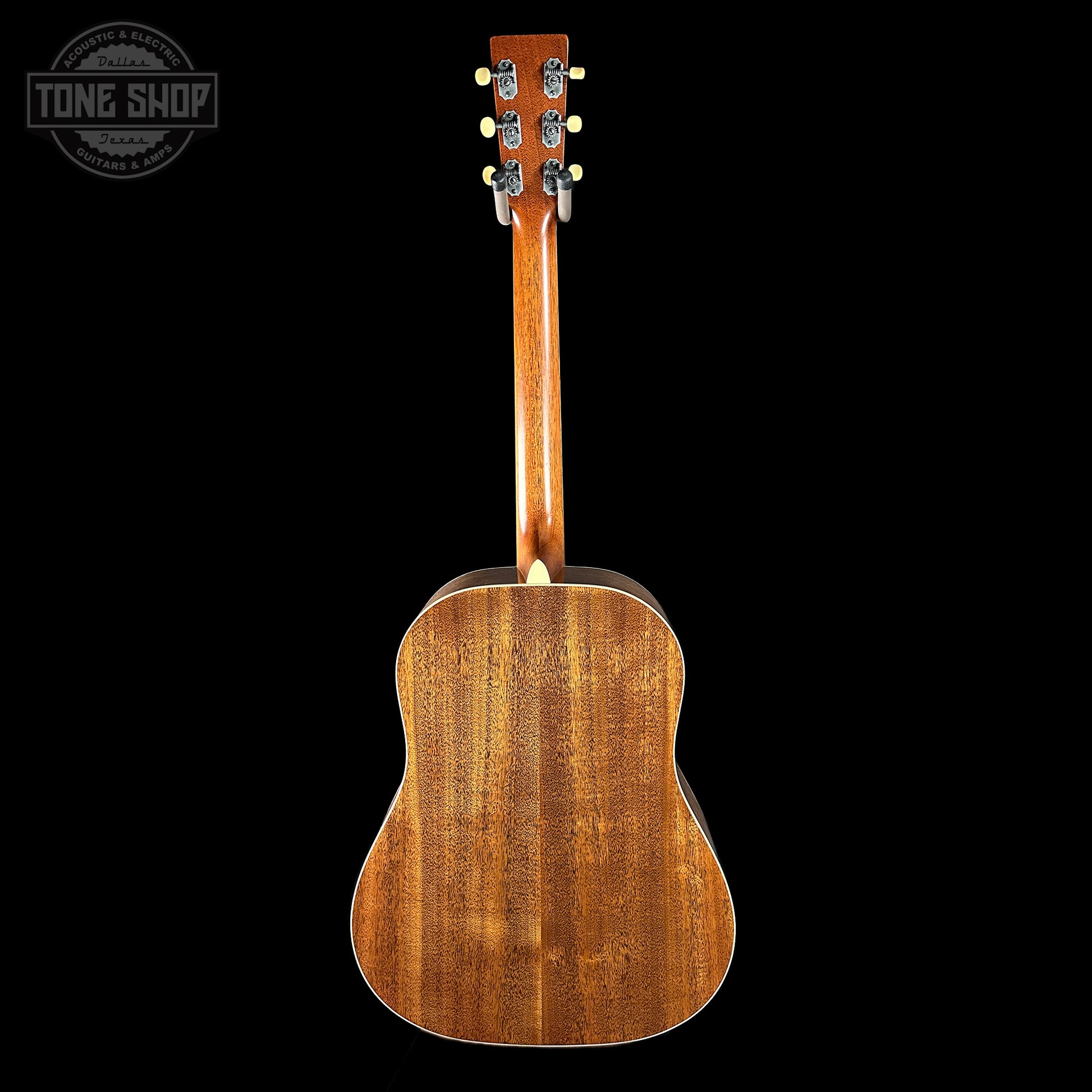 Back view of a wooden acoustic guitar on a black background with 'Tone Shop' logo.