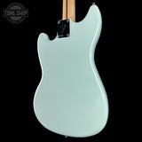 Light blue electric bass guitar on a black background with 'Tone Shop' logo.