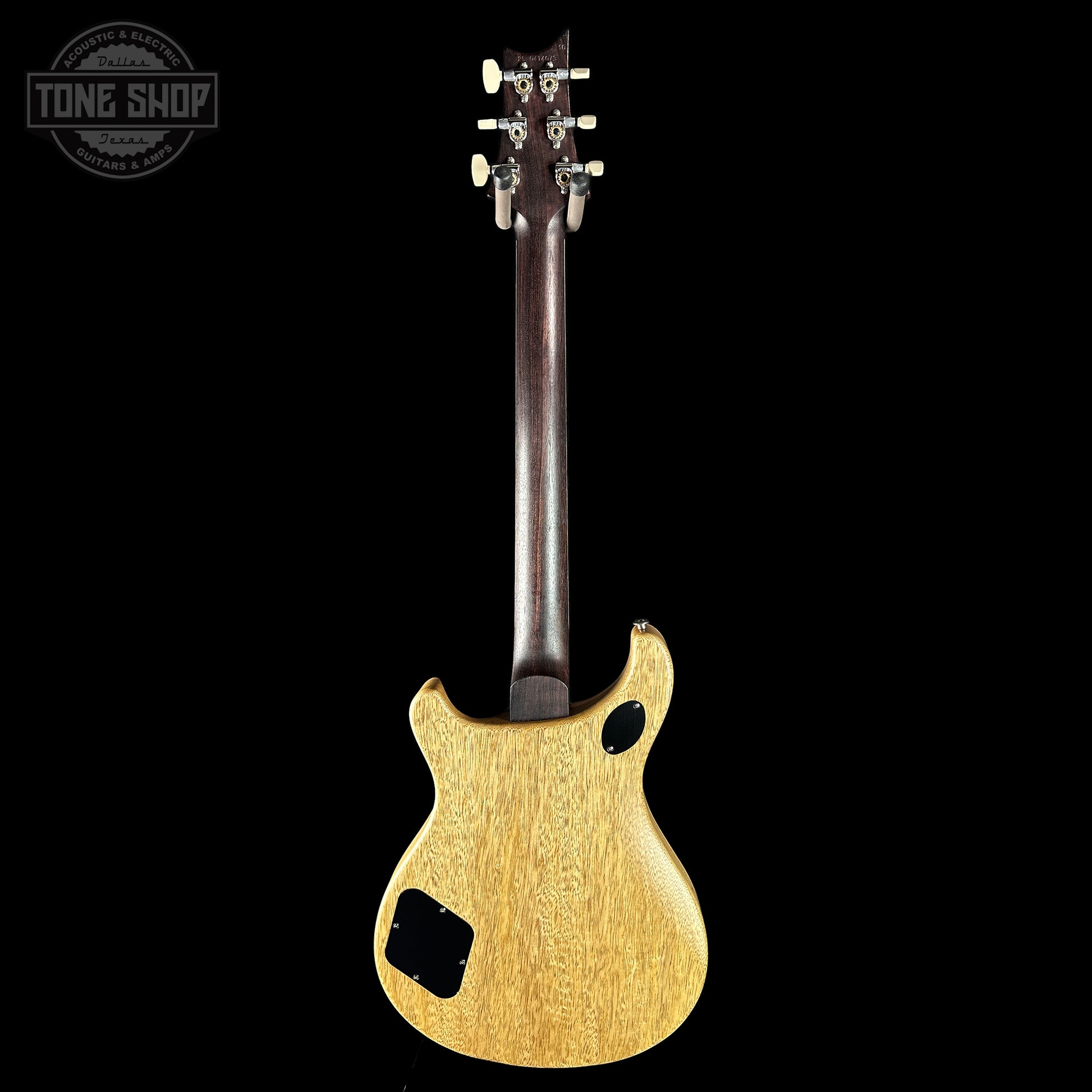 Back view of a wooden electric guitar on a black background with 'Tone Shop' logo.