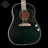 A black acoustic guitar with gold hardware and a striped pickguard, shown against a solid black background with a Tone Shop watermark in the top left corner.